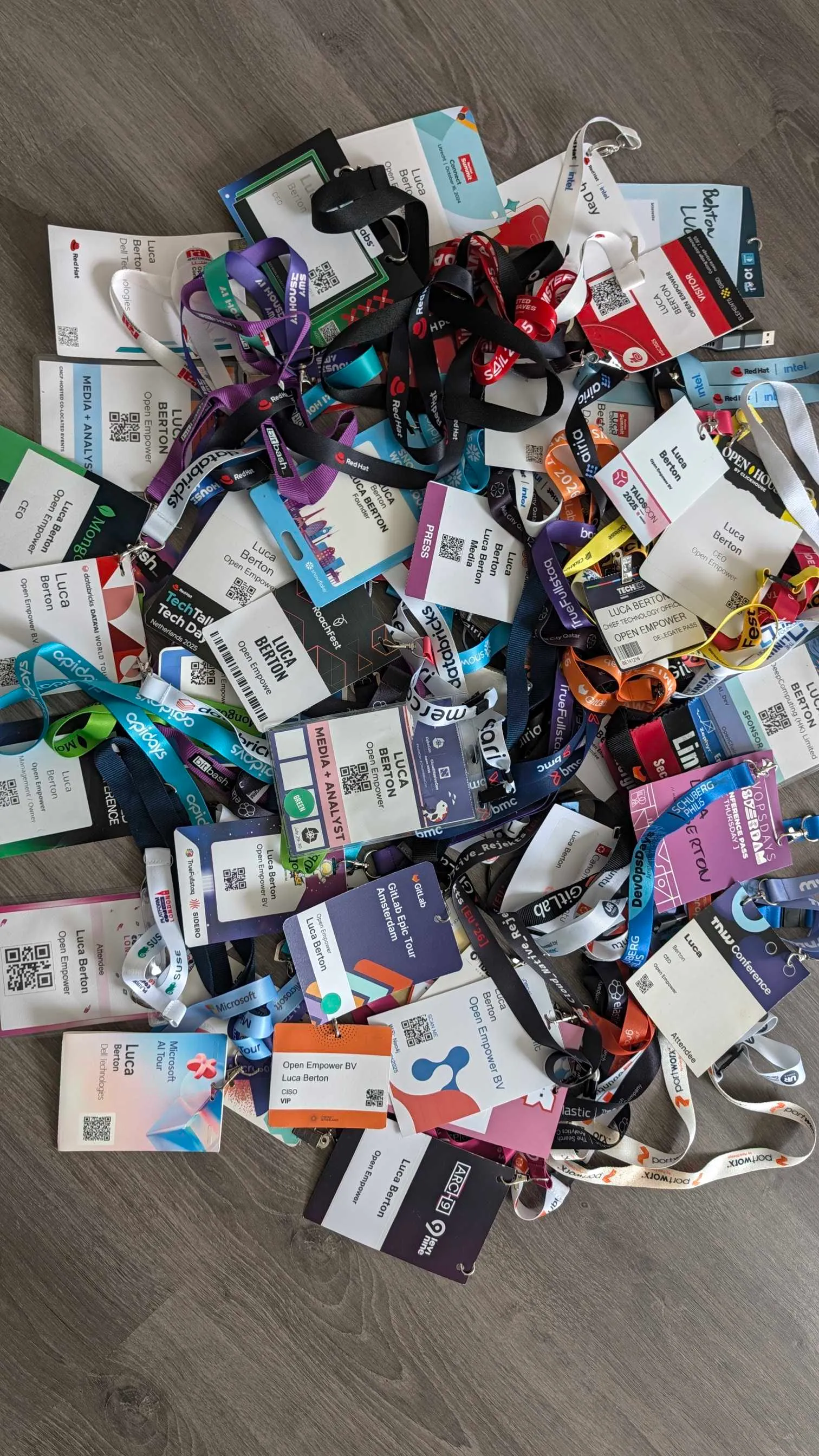 A final pile of conference badges covering AI, Kubernetes and vendor events