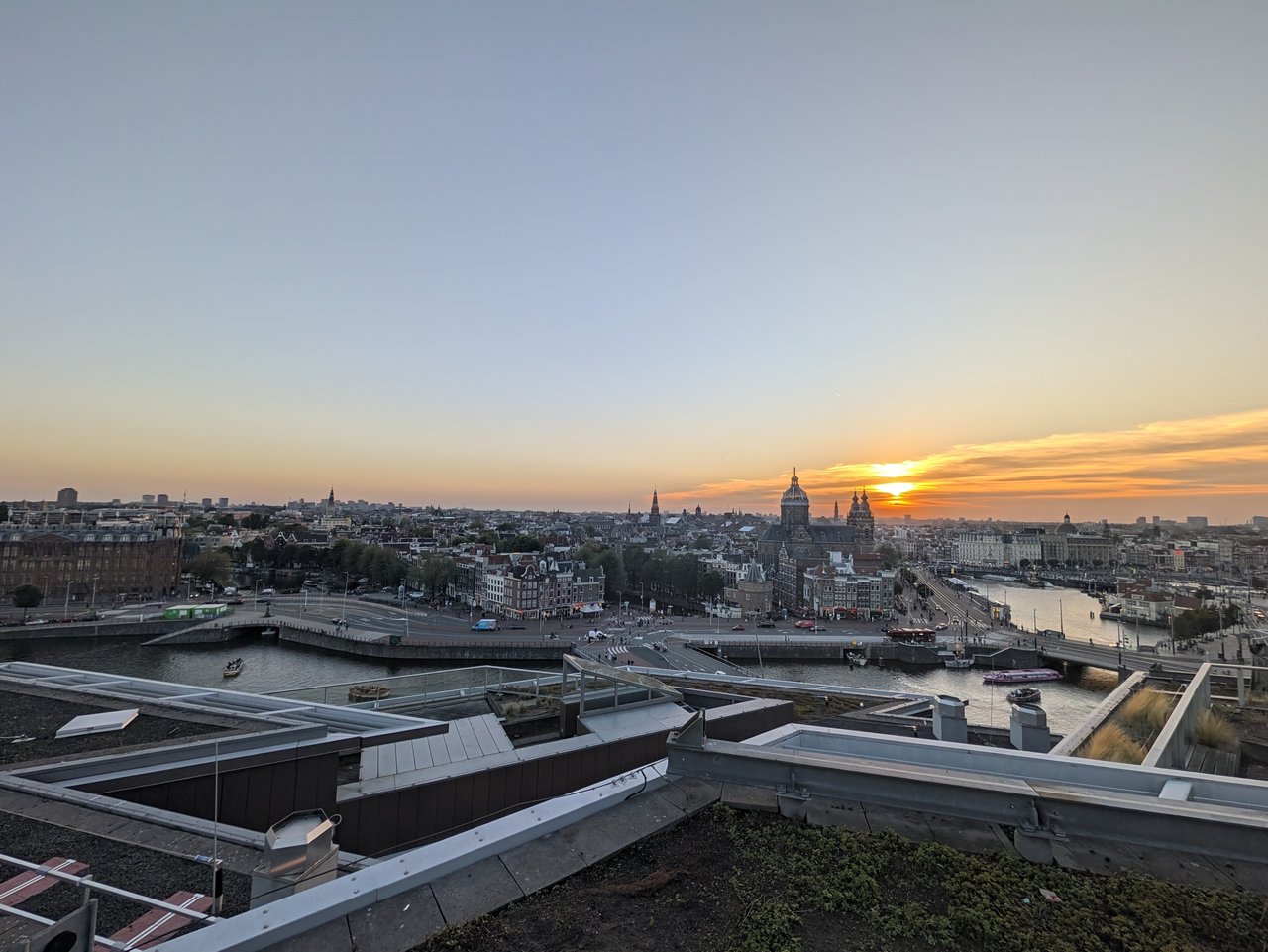 Sunset over Amsterdam's old centre and the Basilica of St Nicholas, seen from a rooftop after the talks