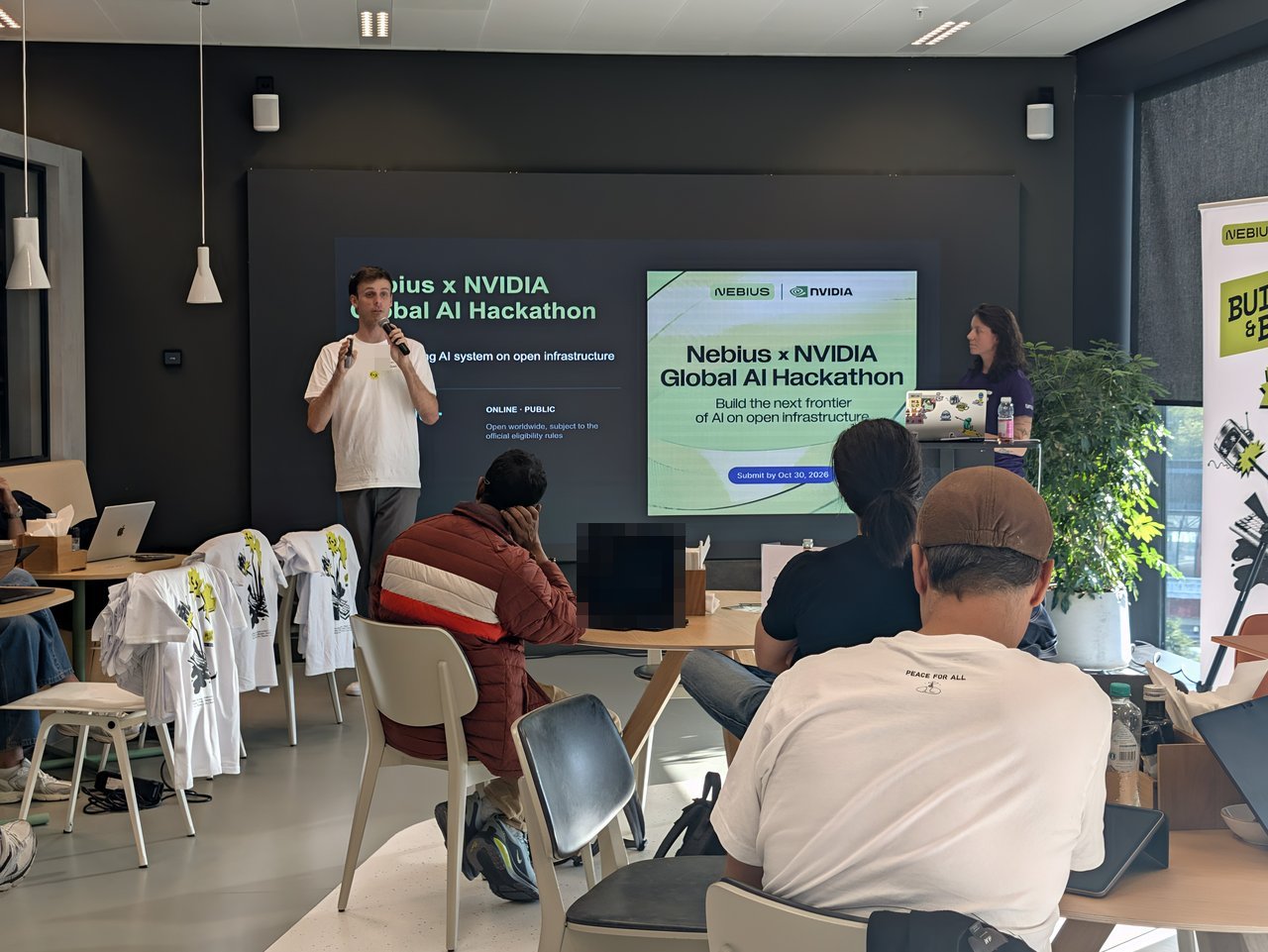 Host presenting the Nebius x NVIDIA Global AI Hackathon slide with Build the next frontier of AI on open infrastructure and Submit by Oct 30 2026