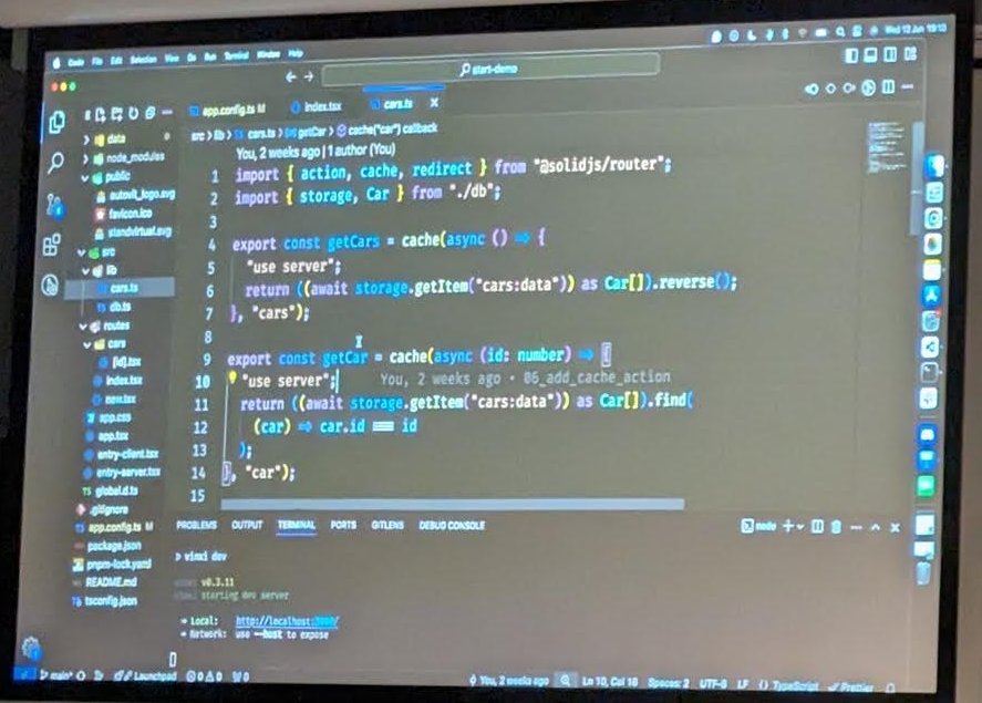 A code editor on the projector showing cache-wrapped getCars and getCar functions with a use server directive, imported from solidjs router