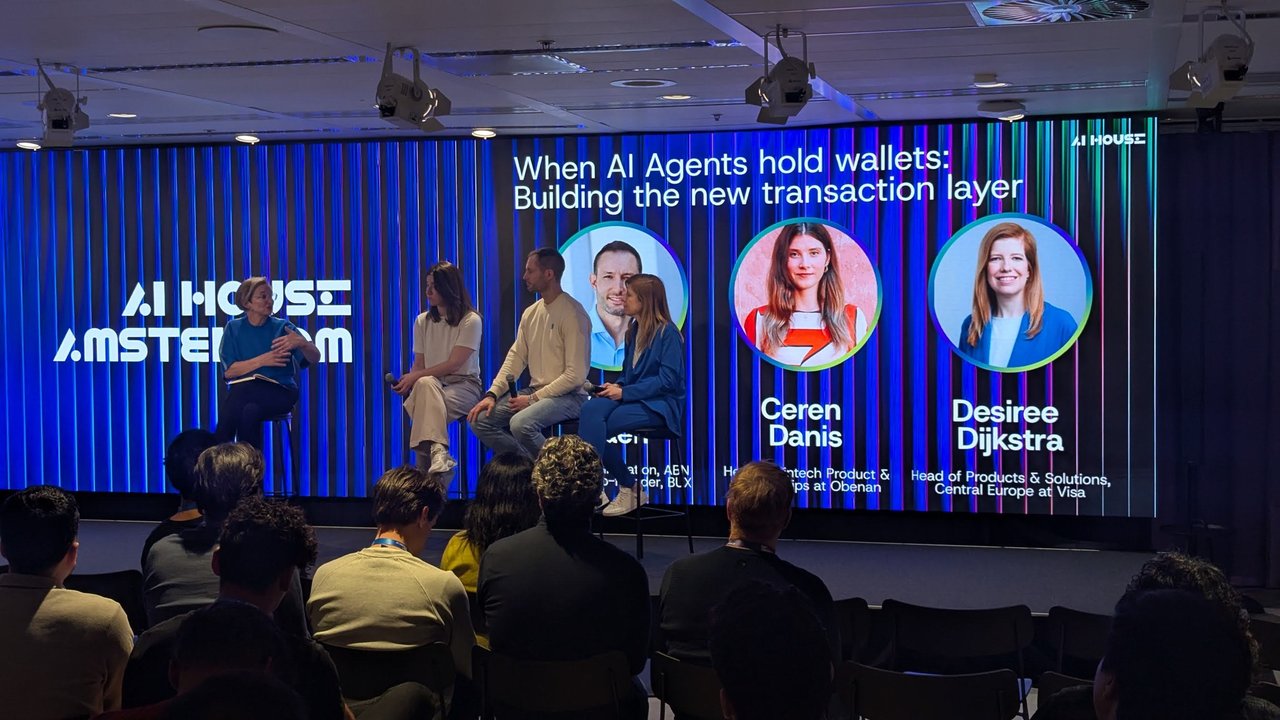 Moderator and panellists on stage under the When AI Agents hold wallets slide with speaker photos at AI House Amsterdam