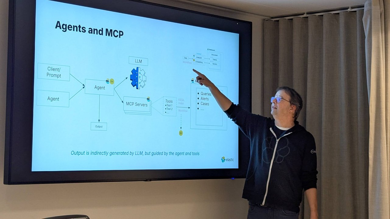 Hans Heerooms pointing at the Agents and MCP slide: a client prompt or another agent calls an agent, which uses an LLM and MCP servers whose tools run ES|QL, index or workflow actions against Elasticsearch queries, alerts and cases
