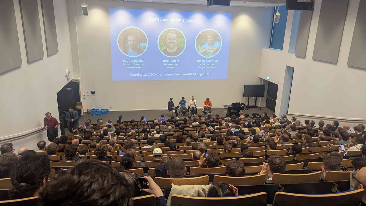 Panel from mid-auditorium — full house, panelists on stage