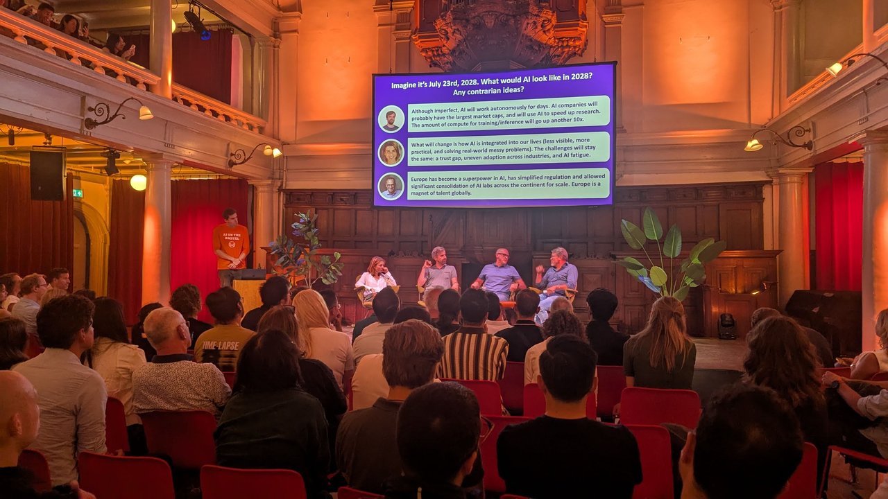 Panel on stage under a slide asking what AI would look like in July 2028, with three answers