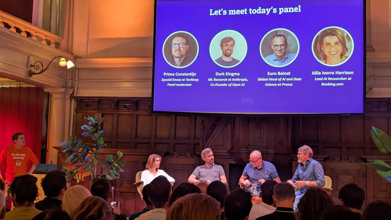 Panel slide with four names and titles, and the four panellists seated below it