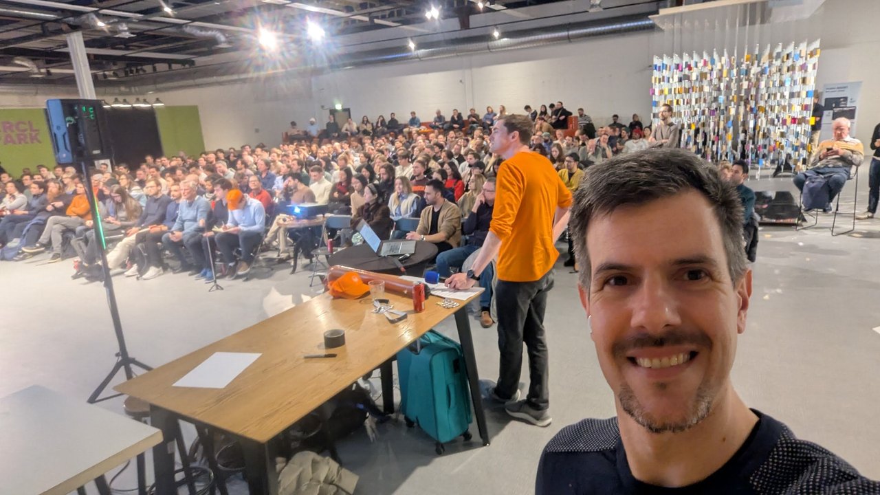 Luca Berton taking a selfie from the front of the CRCL Park theatre, with the full audience of the AI on the Amstel robotics meetup behind him