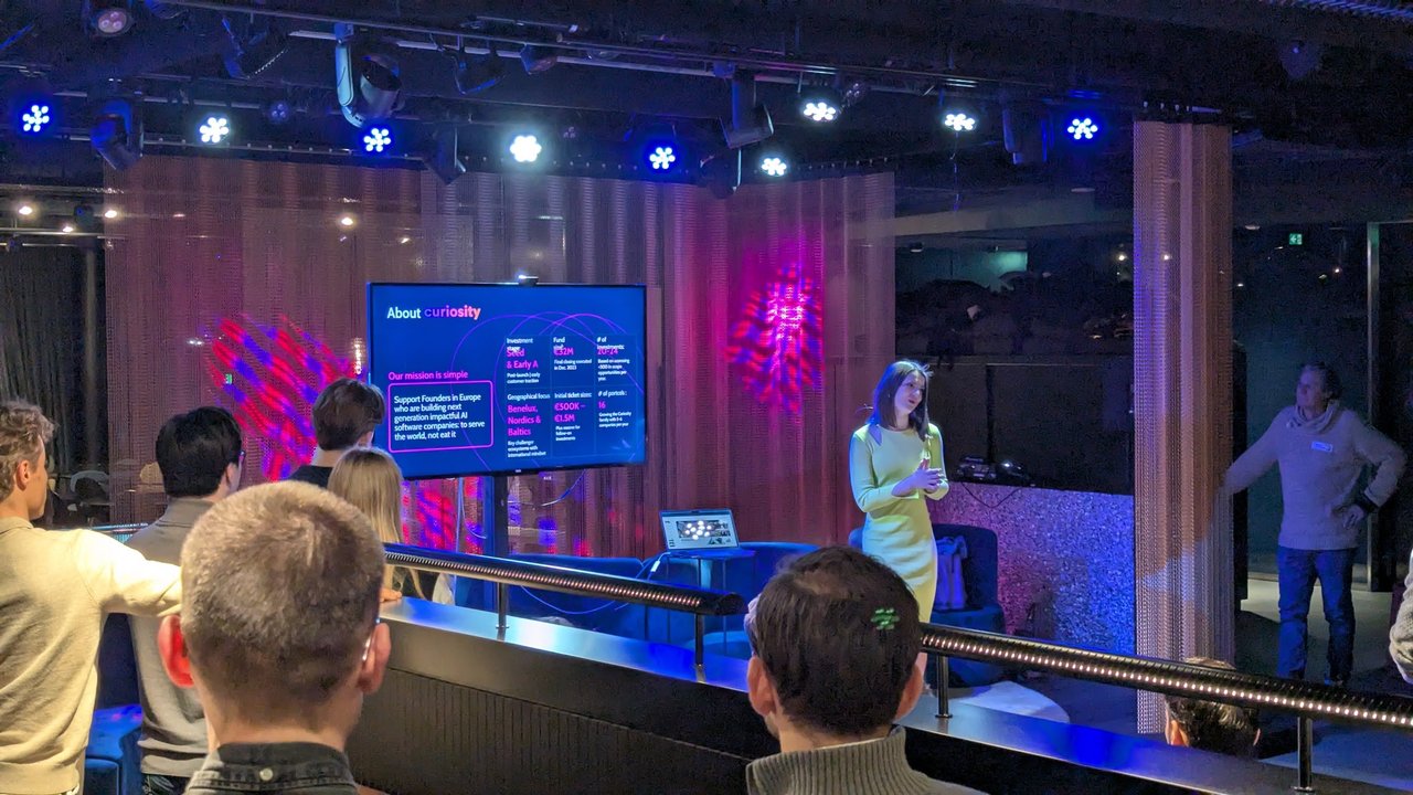 About curiosity slide at AI Salon Amsterdam with the fund's mission, a 32 million euro fund, seed and early A stage, and Benelux, Nordics and Baltics focus