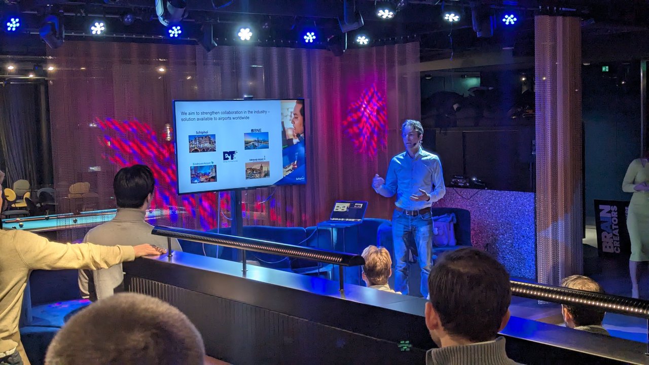 Slide at AI Salon Amsterdam showing Schiphol, BNE, Eindhoven Airport and Edinburgh Airport around the Deep Turnaround logo