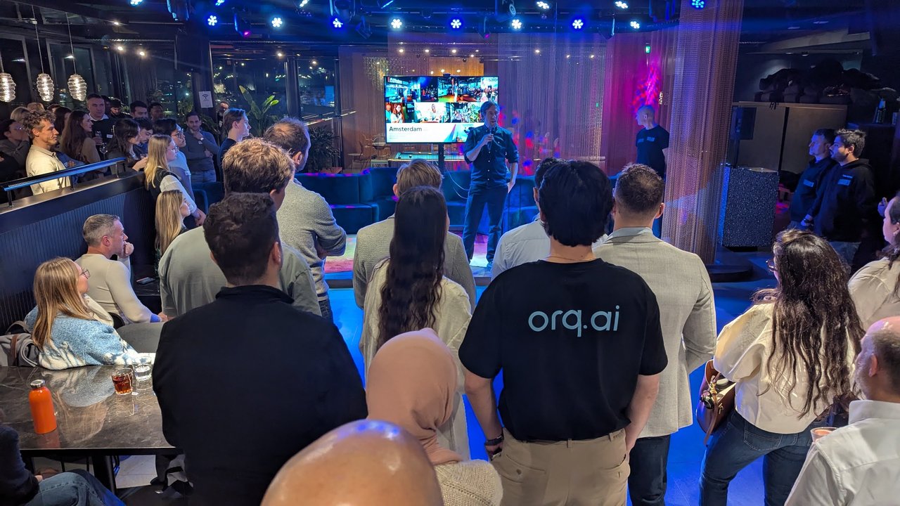 The crowd at AI Salon Amsterdam facing the stage before the startup pitches, with an attendee in an orq.ai T-shirt in the foreground