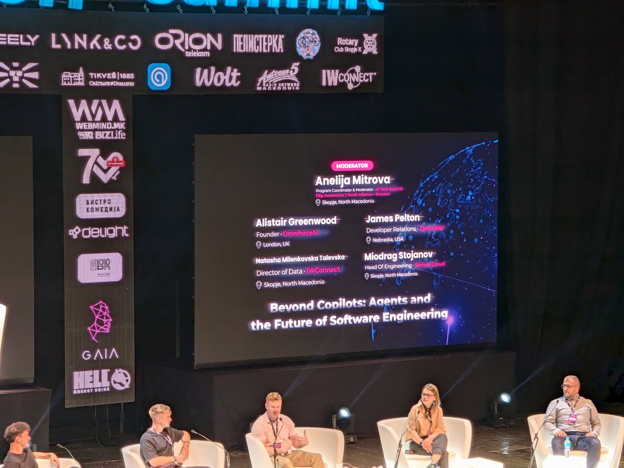 The Beyond Copilots: Agents and the Future of Software Engineering panel on stage, with a slide listing the moderator and four panellists above them