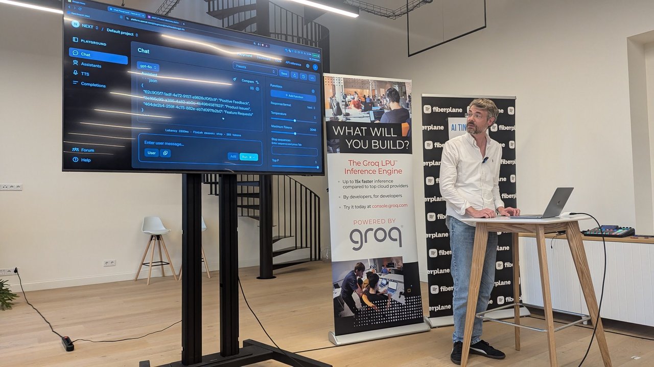 Ronny Roeller at the lectern while the OpenAI Playground on screen shows gpt-4o returning feedback IDs mapped to Positive Feedback, Product Issues and Feature Requests