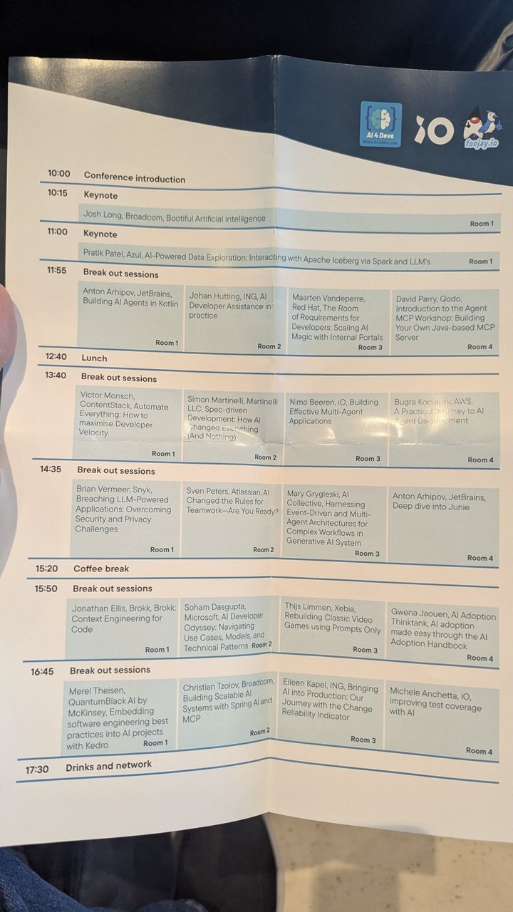 The printed AI4Devs Amsterdam agenda, with the two keynotes and four breakout slots across Rooms 1 to 4, from conference introduction at 10:00 to drinks and networking at 17:30
