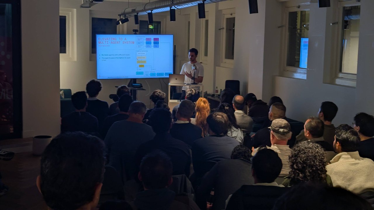 ML6 speaker presenting the Elevating to a Multi-Agent System deep research architecture slide