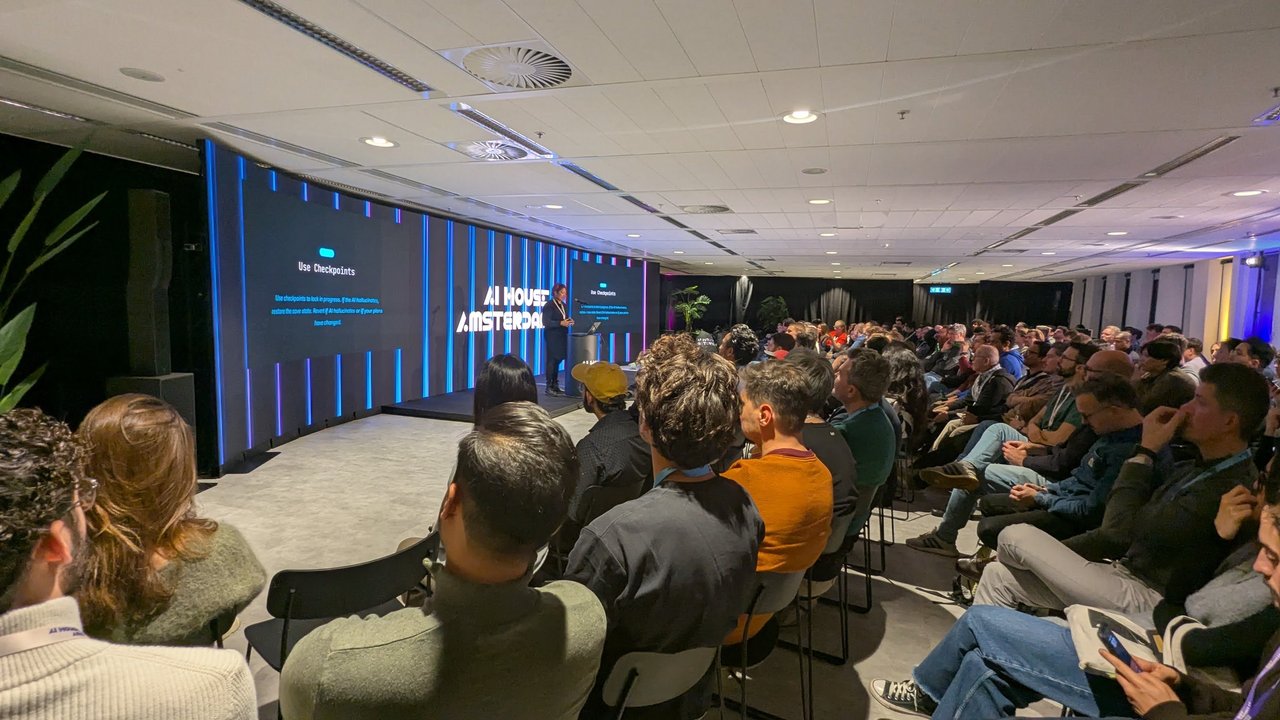 A full AI House Amsterdam auditorium during the Google coding-assistants session, with the slide Use Checkpoints on the big screens