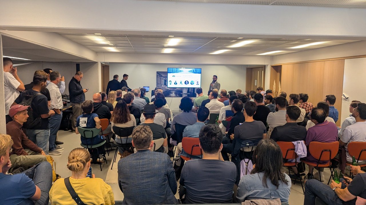 A packed meetup room at Spaces Amstel during the LangChain AI Agents Meetup, with every seat taken and people standing at the back