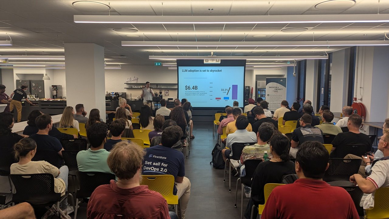 Wide view of the full room at the Datadog office in Amsterdam during the GenAI Meetup, with the "LLM adoption is set to skyrocket" slide on screen