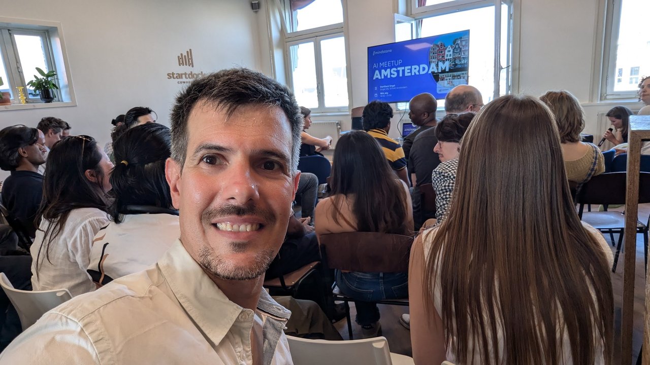Luca Berton at the Mindstone AI Meetup Amsterdam at Startdock, with the AI Meetup Amsterdam welcome slide on the screen behind him