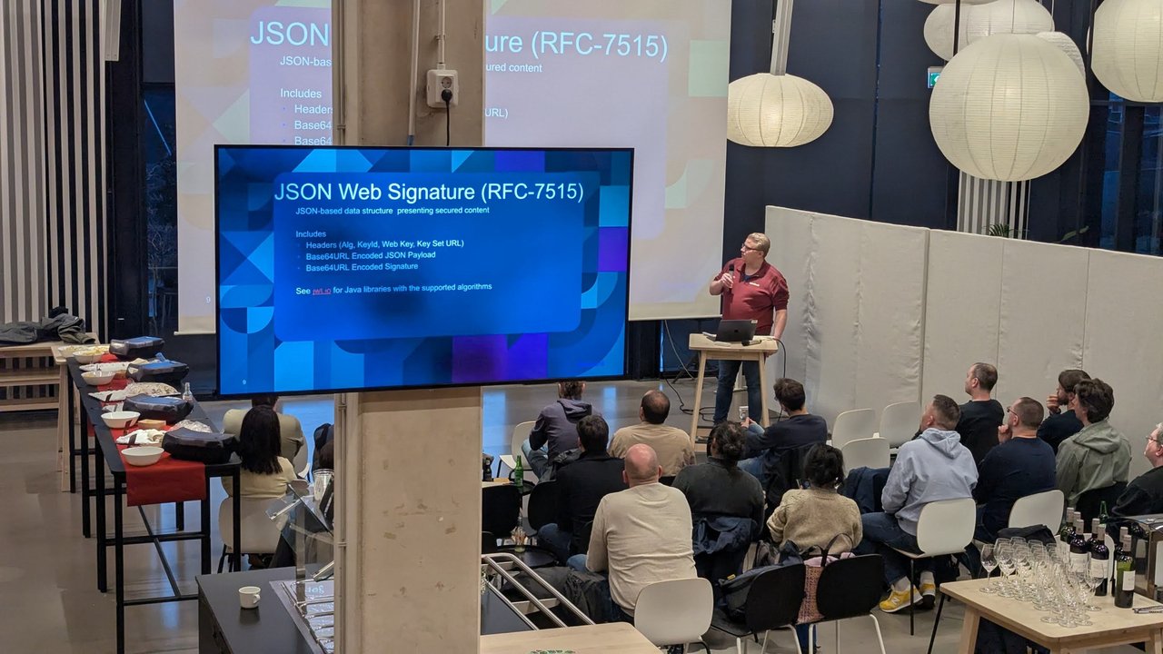 JSON Web Signature (RFC-7515) slide at the Amsterdam Java User Group meetup at IKEA listing headers, Base64URL-encoded JSON payload and Base64URL-encoded signature