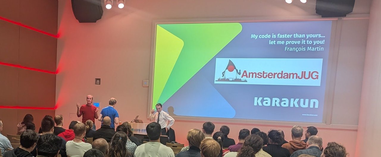 Audience in a full room at ABN AMRO facing the Amsterdam JUG title slide My code is faster than yours… let me prove it to you!, François Martin, with the Karakun logo