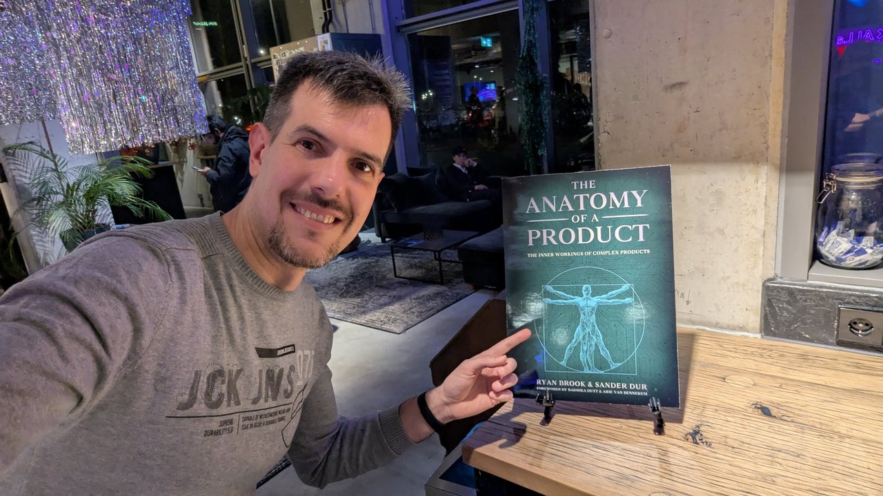 Luca Berton pointing at a display copy of The Anatomy of a Product by Ryan Brook and Sander Dur