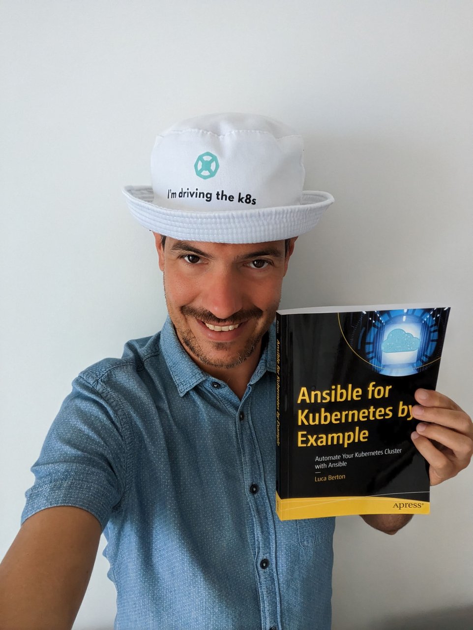 Luca Berton holding a printed copy of Ansible for Kubernetes by Example, published by Apress