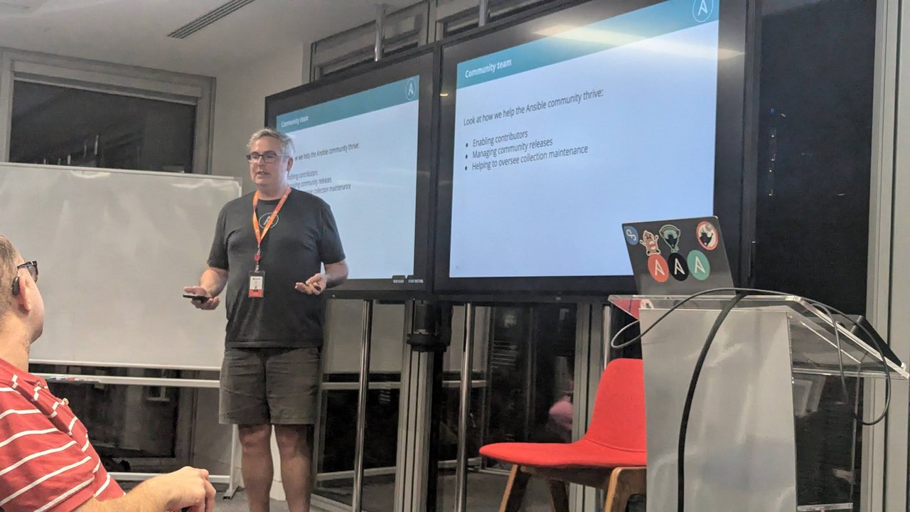 A member of the Ansible community team presenting the 'Community team' slide: enabling contributors, managing community releases, helping to oversee collection maintenance