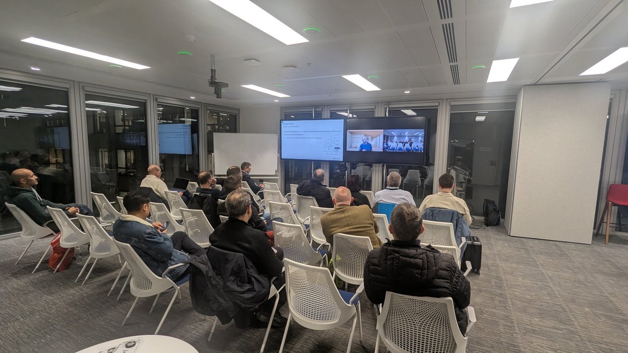 The Ansible London audience watching a remote speaker on a video call next to a slide titled Ansible RAG, November 2024