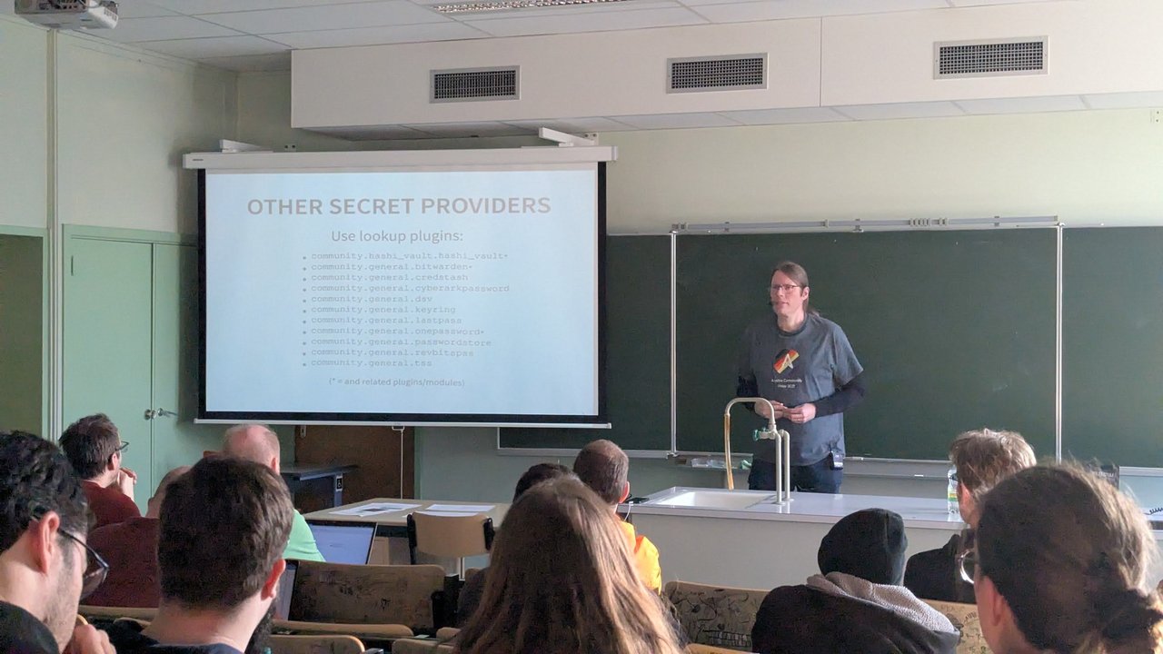 An "Other secret providers" slide at CfgMgmtCamp 2025 in Ghent listing lookup plugins such as community.hashi_vault.hashi_vault, community.general.bitwarden, onepassword and keyring