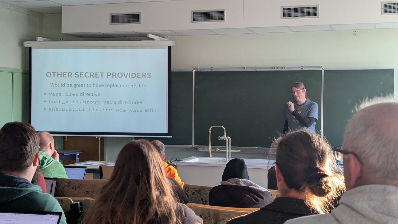 An "Other secret providers" wish-list slide at CfgMgmtCamp 2025 in Ghent asking for replacements for the vars_files directive, host_vars and group_vars directories and the ansible.builtin.include_vars action