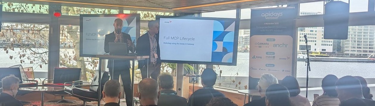 The title slide of the Full MCP Lifecycle workshop using the Axway AI Gateway on two screens in the room, with the river IJ in the background