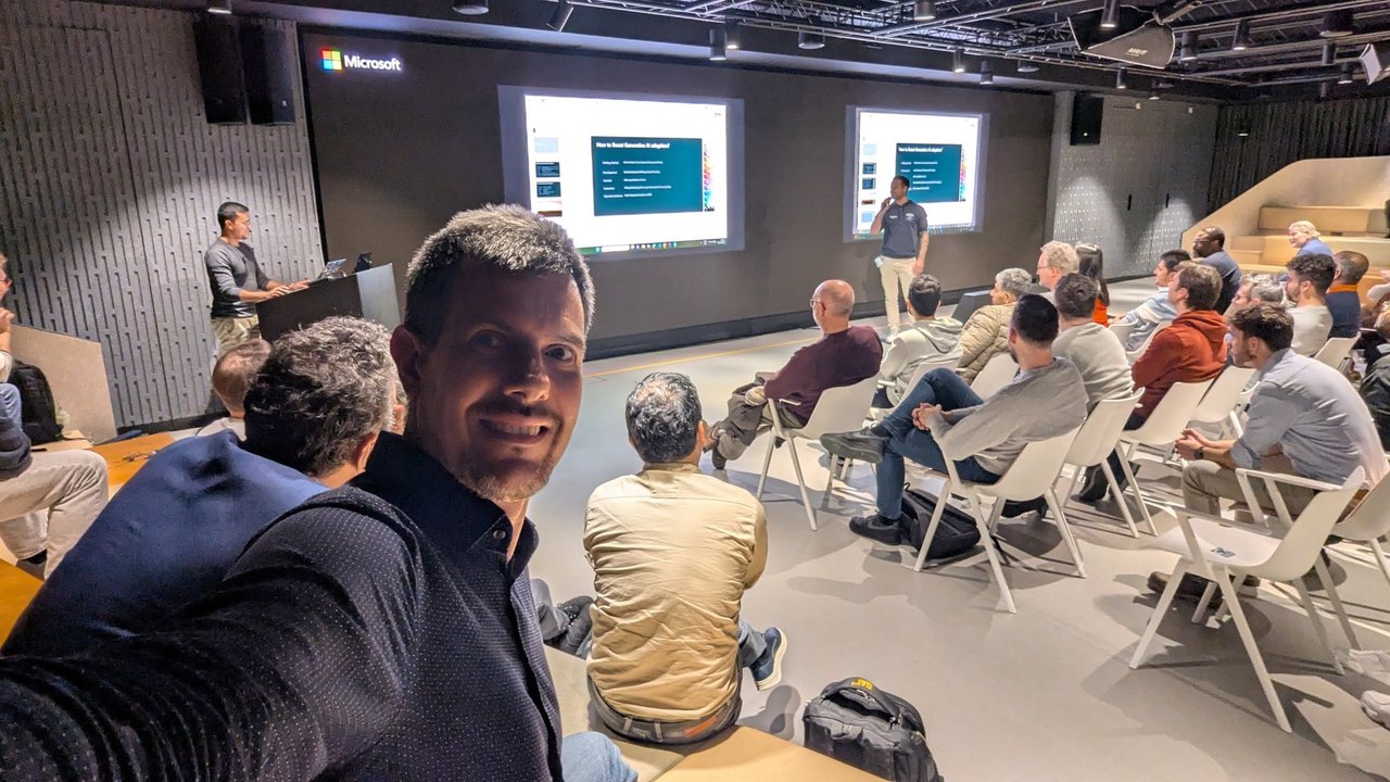 The speaker's closing slide, How to Boost Generative AI adoption, listing getting started, development, context, evaluation and operationalization, with the speaker standing in front of the right-hand screen