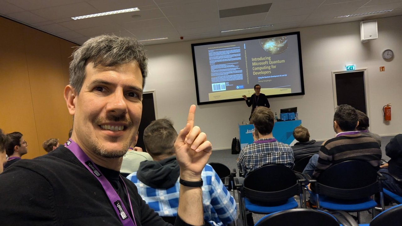 Luca Berton pointing at the Introducing Microsoft Quantum Computing for Developers book cover on screen at BitBash 2025