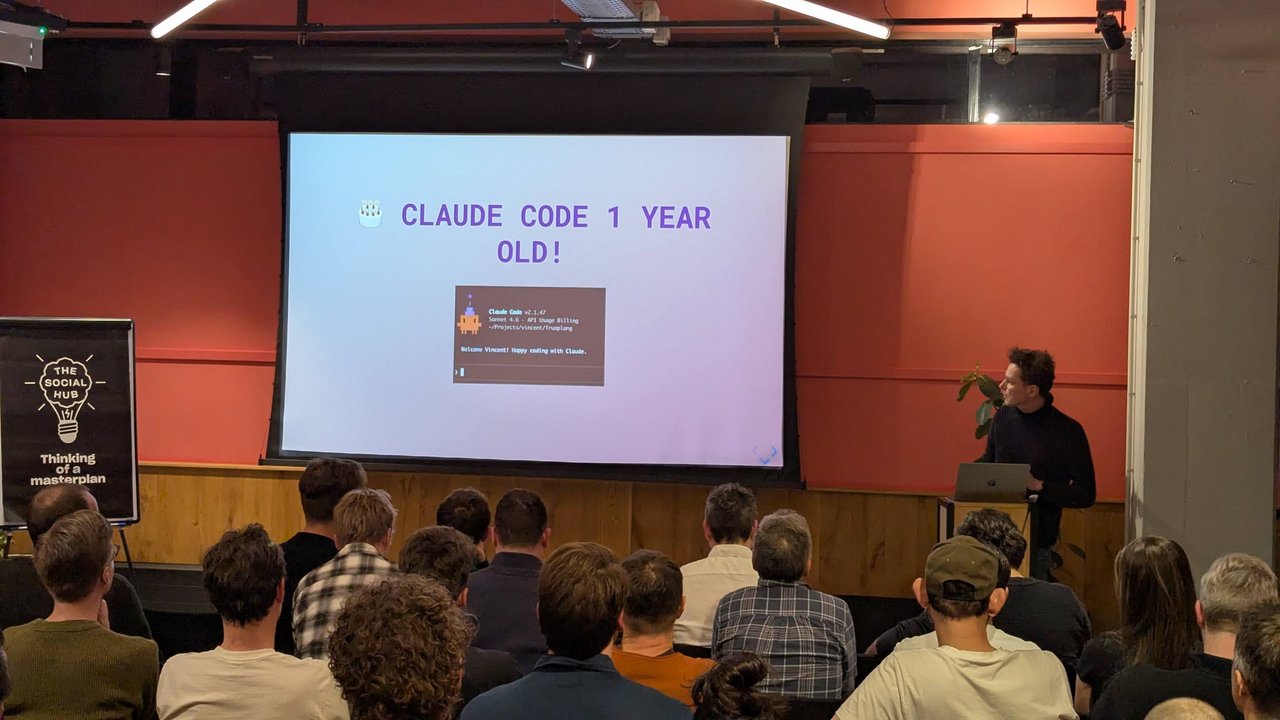 Claude Code 1 Year Old slide at Claude Code Meetup Amsterdam with a Claude Code v2.1.47 welcome screen in front of a full room