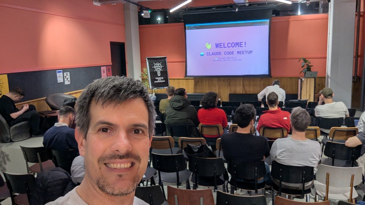 Luca Berton in the meetup room at The Social Hub City in Amsterdam, with the Welcome Claude Code Meetup slide on the screen behind him