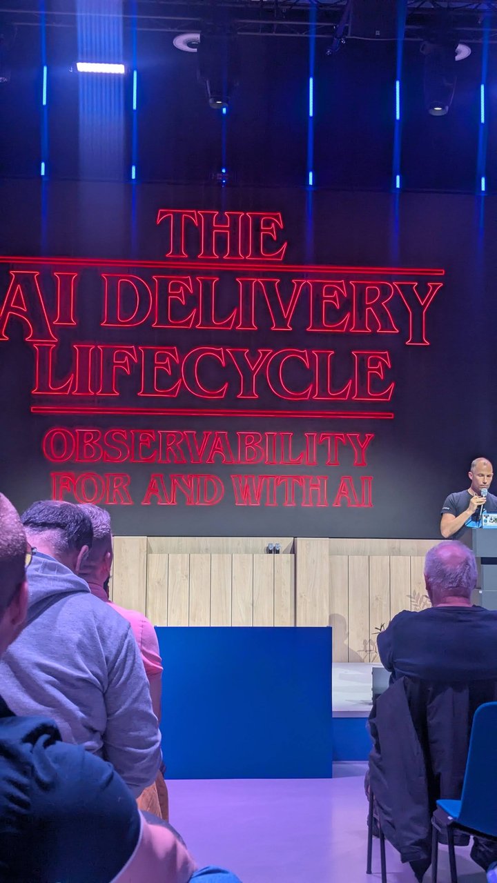 Andi Grabner on stage at Signal Overflow at Booking.com beside the title slide The AI Delivery Lifecycle: Observability for and with AI