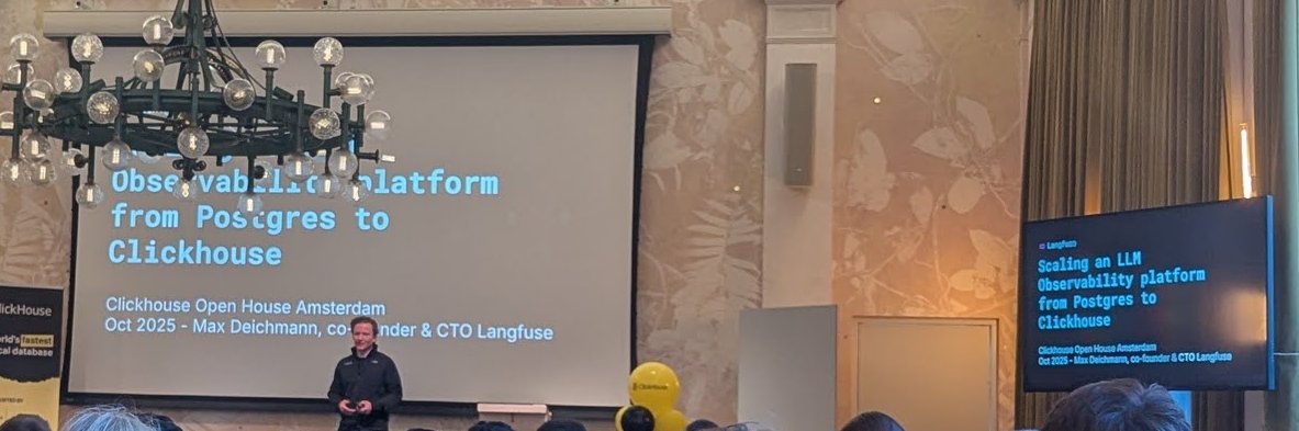 Max Deichmann on stage at ClickHouse Open House Amsterdam, with the title Scaling an LLM Observability platform from Postgres to Clickhouse on the main screen and on the side screen
