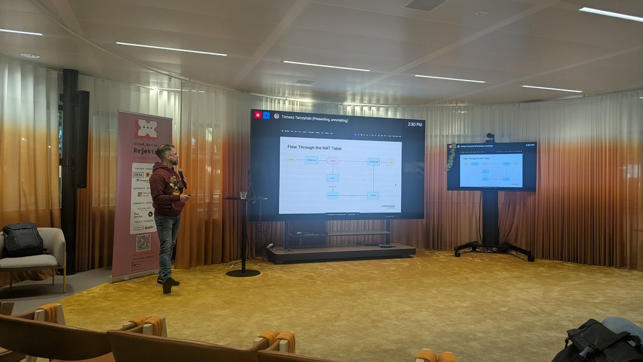 Tomasz Tarczyński presenting Life of a Packet on Kubernetes ClusterIP networking without kube-proxy at Cloud Native Rejekts 2026
