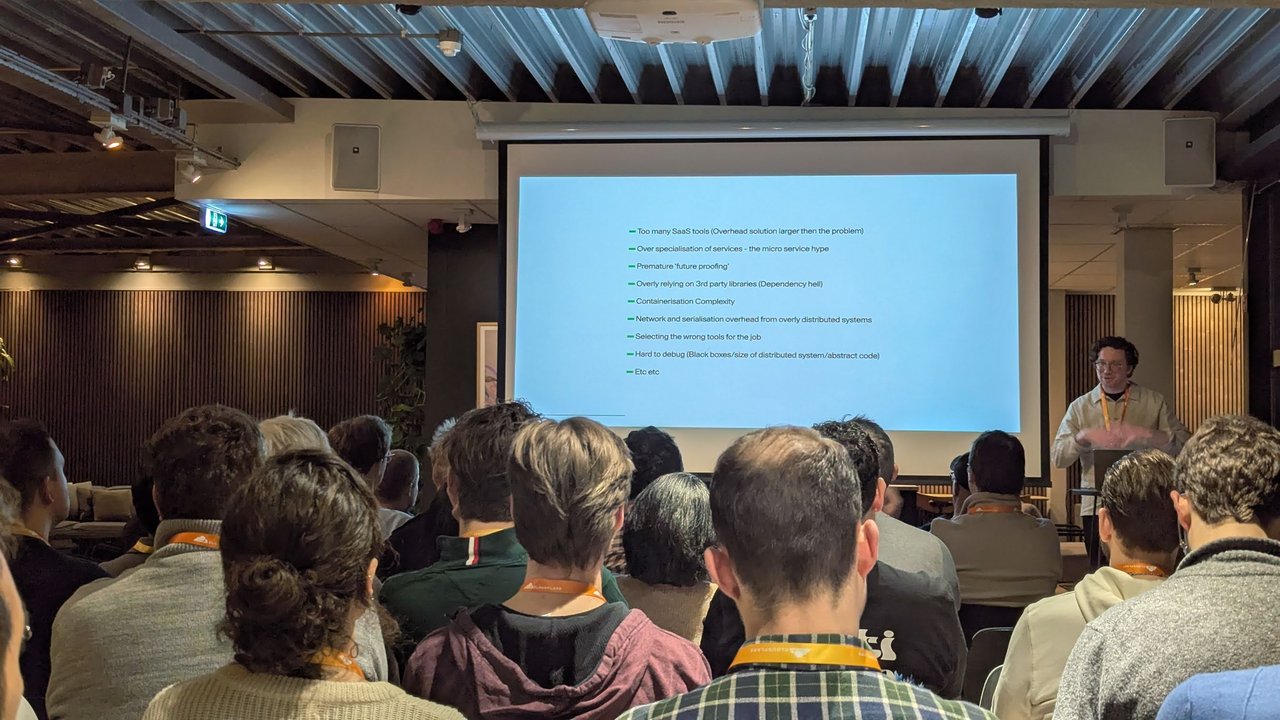 Slide listing causes of slow software at the Cloudflare meetup: SaaS sprawl, microservice hype, dependency hell, containerisation complexity and distributed-system overhead