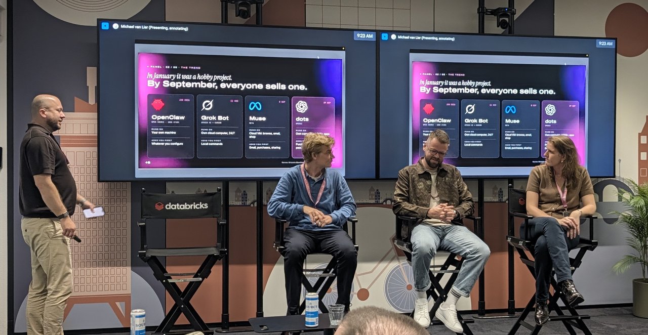 Panel on stage at Databricks Amsterdam in front of two screens showing the slide In January it was a hobby project. By September, everyone sells one