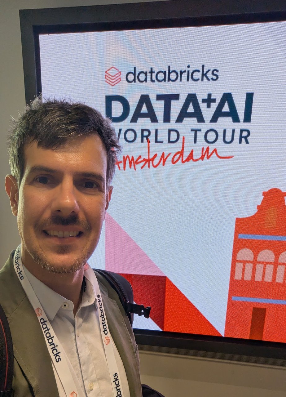 Luca Berton smiling in front of a Databricks DATA+AI World Tour Amsterdam screen