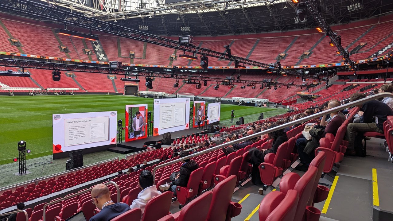 The Databricks stage and screens set up on the grass of the Johan Cruijff ArenA, seen from the lower stands