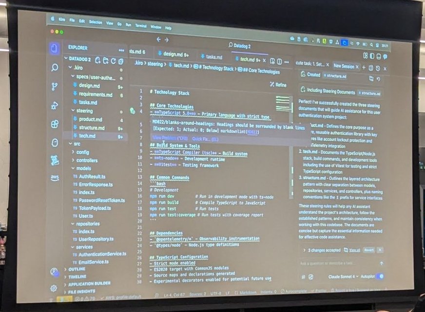 Kiro on the projector during the demo, with the .kiro steering folder containing product.md, structure.md and tech.md and a Technology Stack document open in the editor