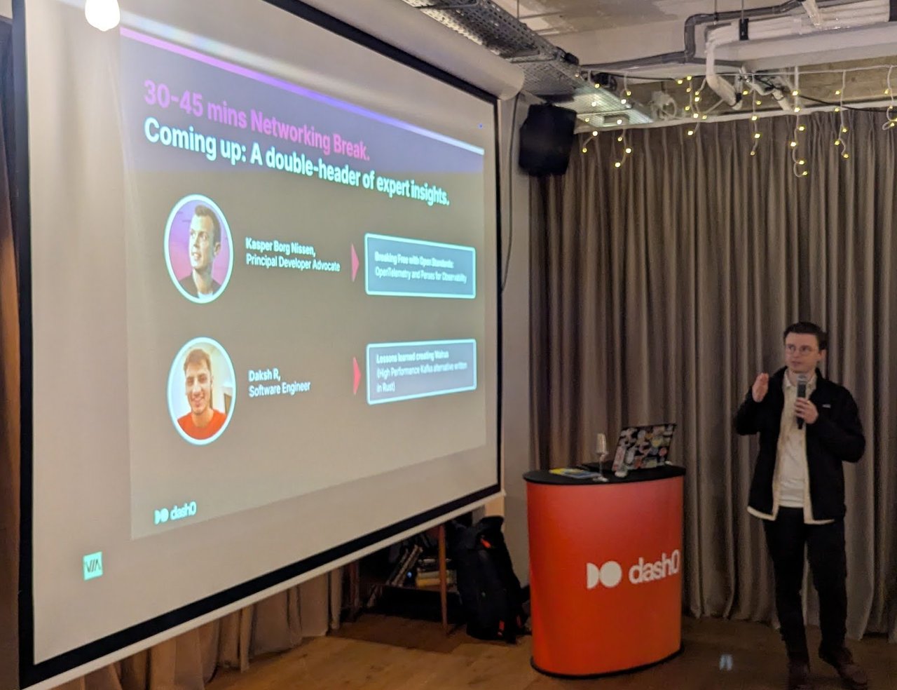Host on stage next to the agenda slide: 30-45 mins Networking Break, Coming up: A double-header of expert insights, with Kasper Borg Nissen, Principal Developer Advocate, and Daksh R, Software Engineer