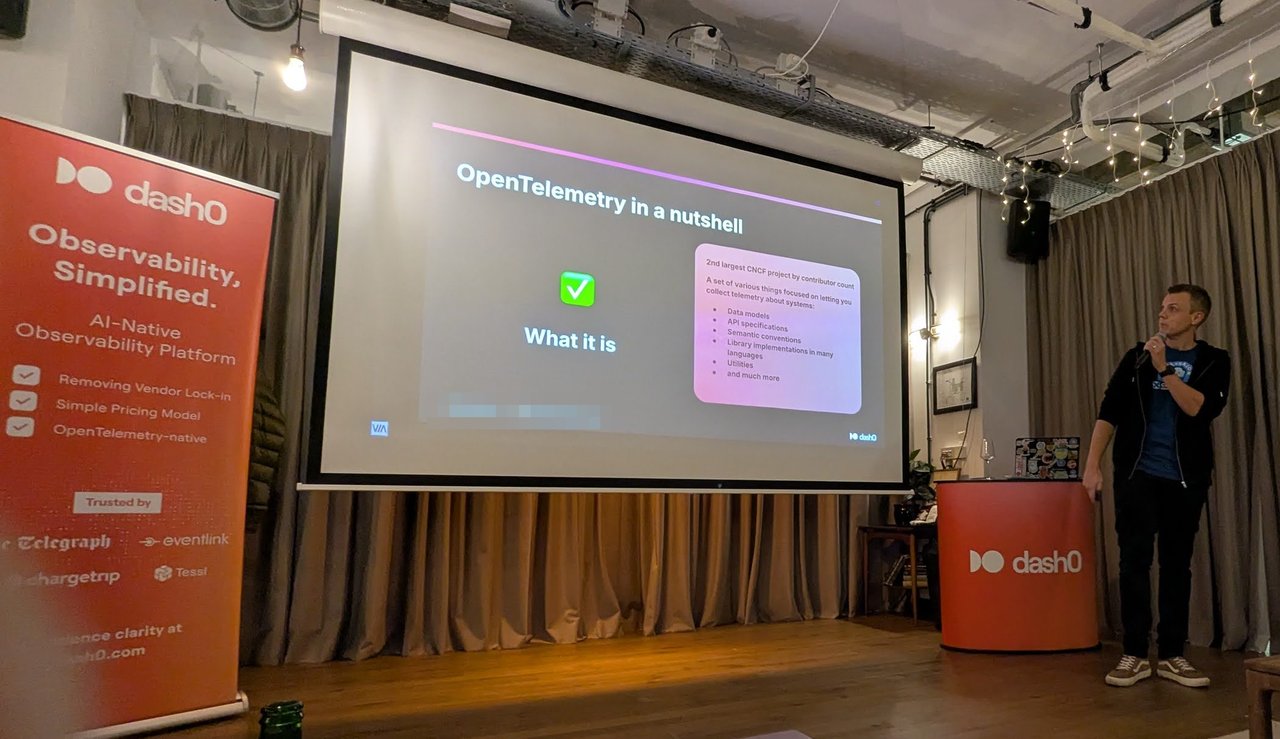 Kasper Borg Nissen next to the slide OpenTelemetry in a nutshell, What it is, listing data models, API specifications, semantic conventions, library implementations in many languages and utilities, beside a Dash0 roll-up banner