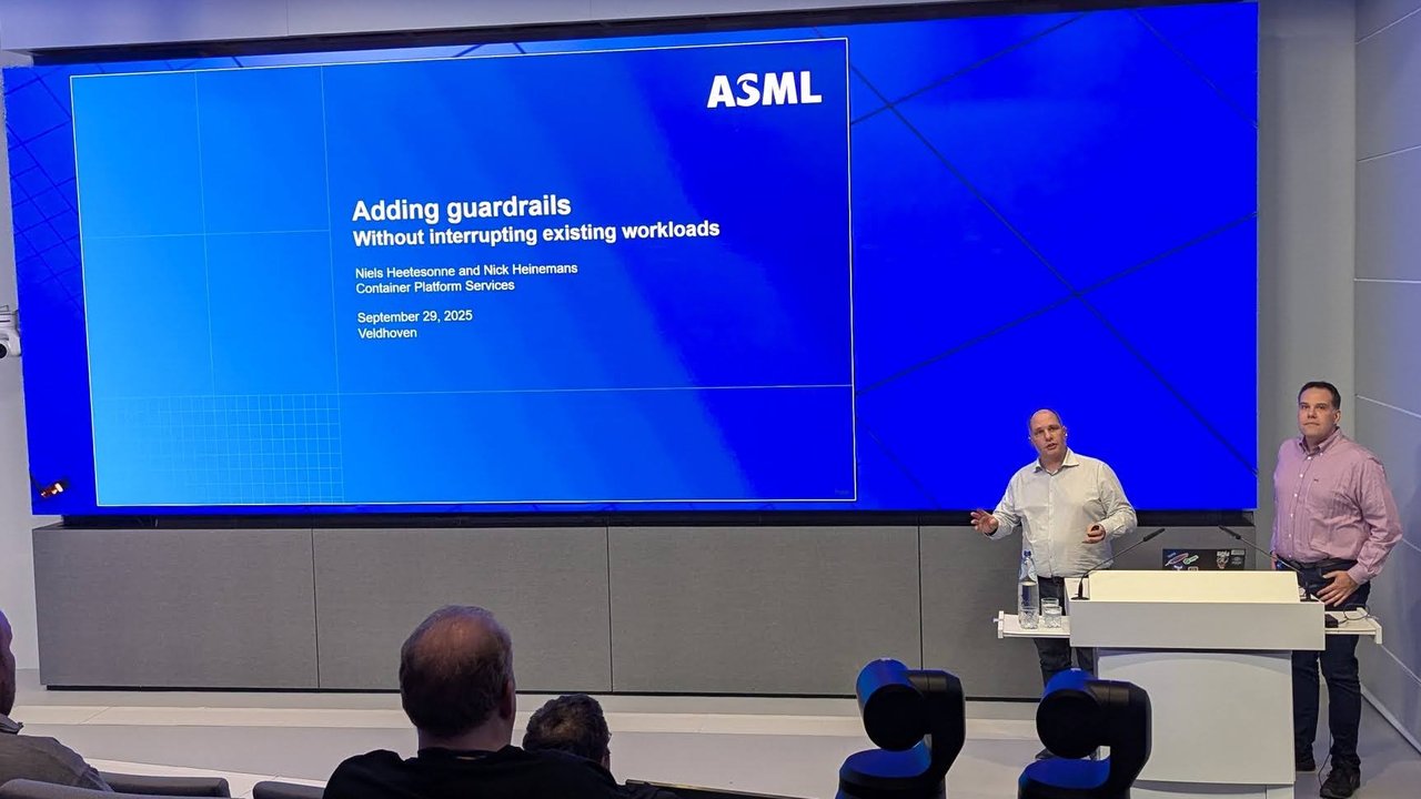Niels Heetesonne and Nick Heinemans on stage next to their ASML title slide, Adding guardrails, Without interrupting existing workloads, dated September 29, 2025, Veldhoven