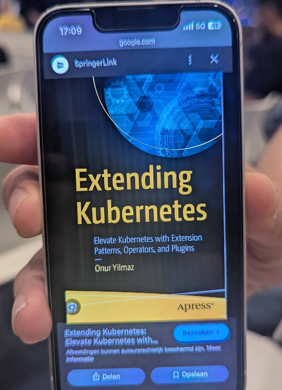 Phone screen showing the book Extending Kubernetes, Elevate Kubernetes with Extension Patterns, Operators, and Plugins, published by Apress