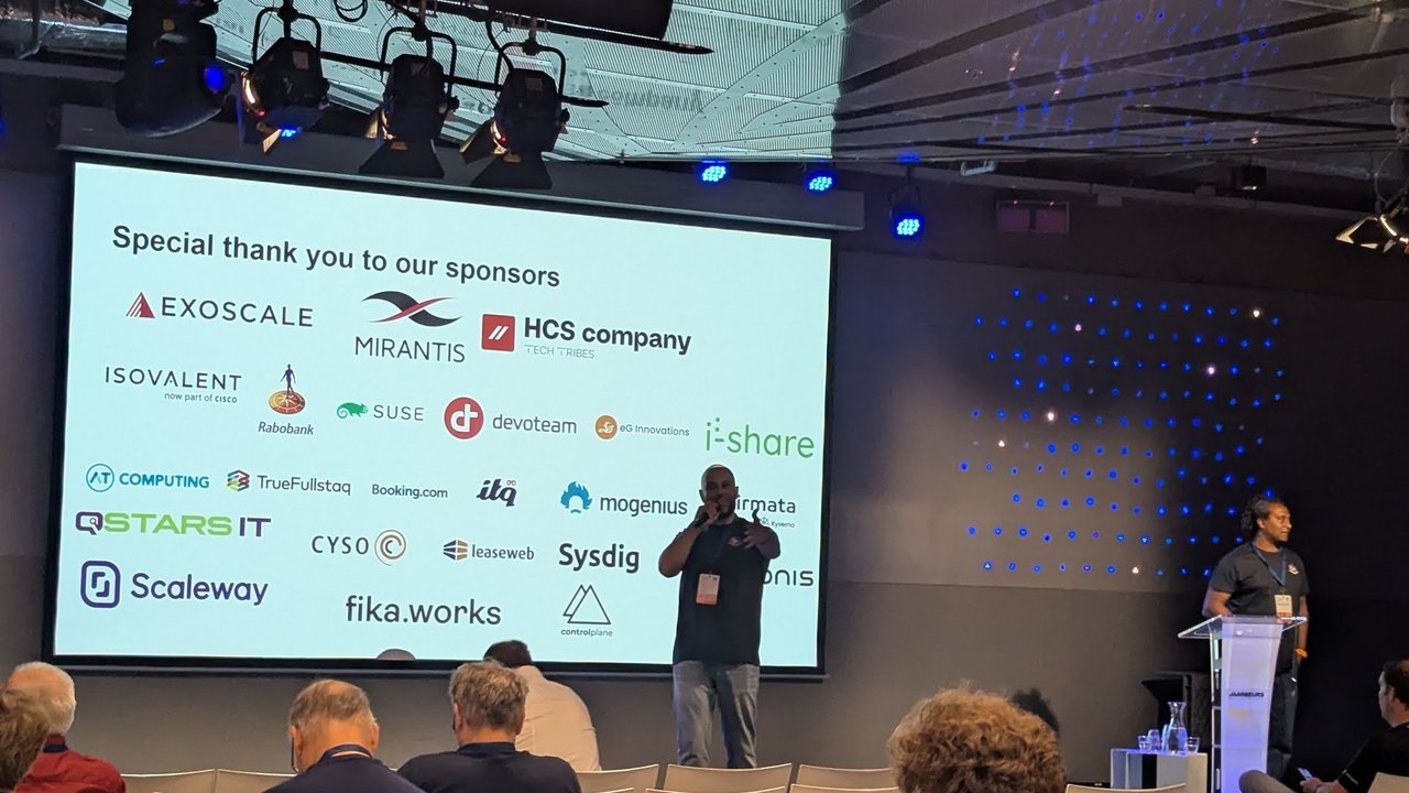 Closing slide Special thank you to our sponsors with the logos of Exoscale, Mirantis, HCS company, Isovalent, Rabobank, SUSE, Devoteam, TrueFullstaq, Booking.com, Sysdig, Scaleway and others, with two organisers on stage