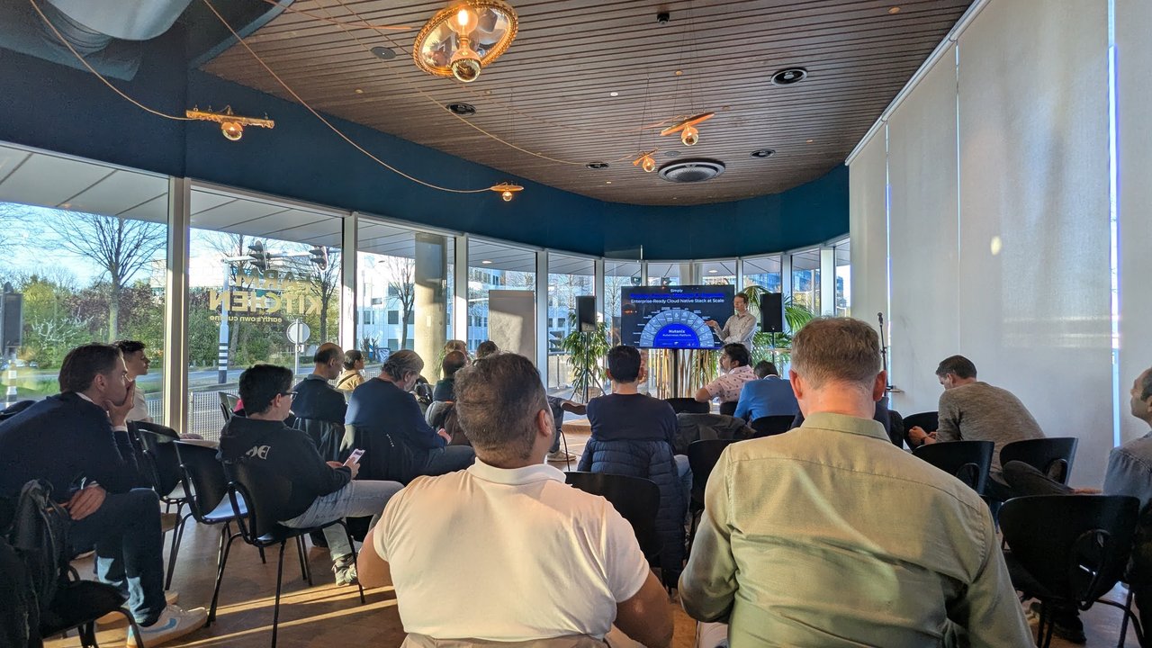 Attendees seated in a glass-walled meetup room at Nutanix in Hoofddorp, with the presentation screen at the front