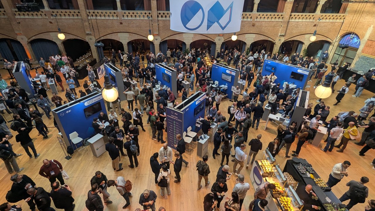 The ElasticON Amsterdam expo floor seen from the balcony of the Beurs van Berlage, with blue Elastic stands and a large Elastic ON banner