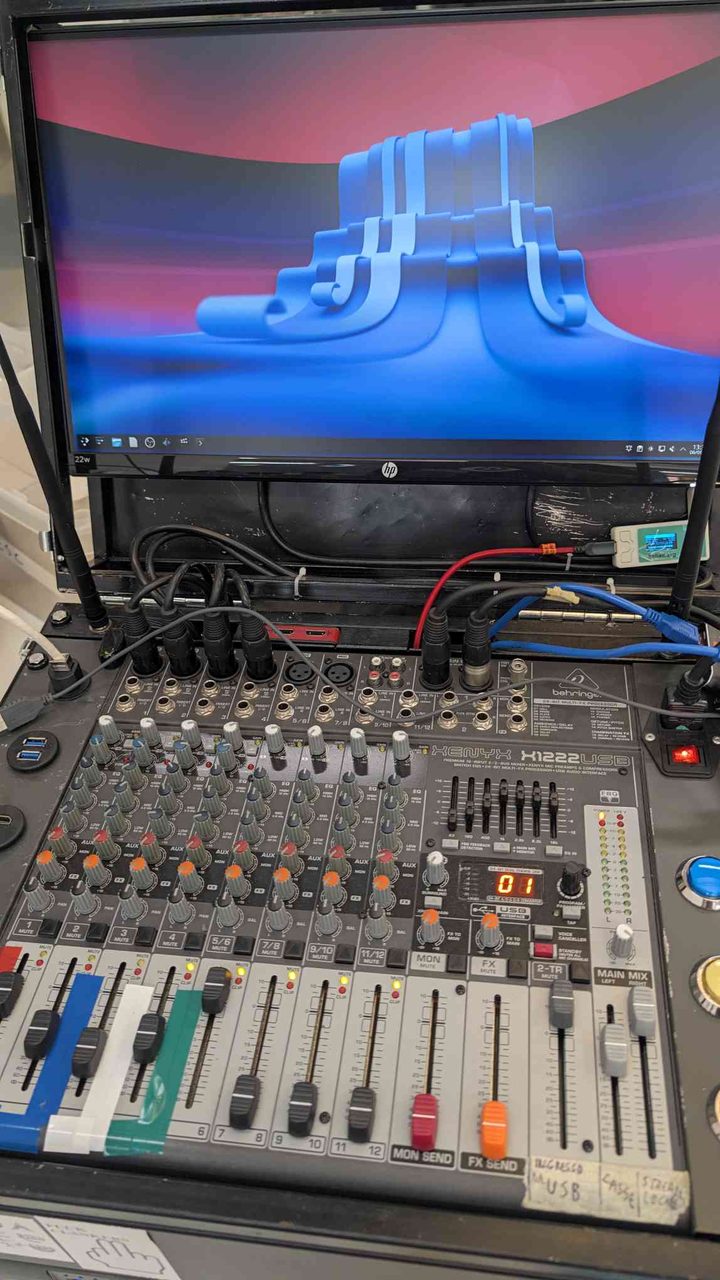 The Behringer Xenyx X1222USB mixer at ESC — 12 channels of audio chaos, taped faders and all